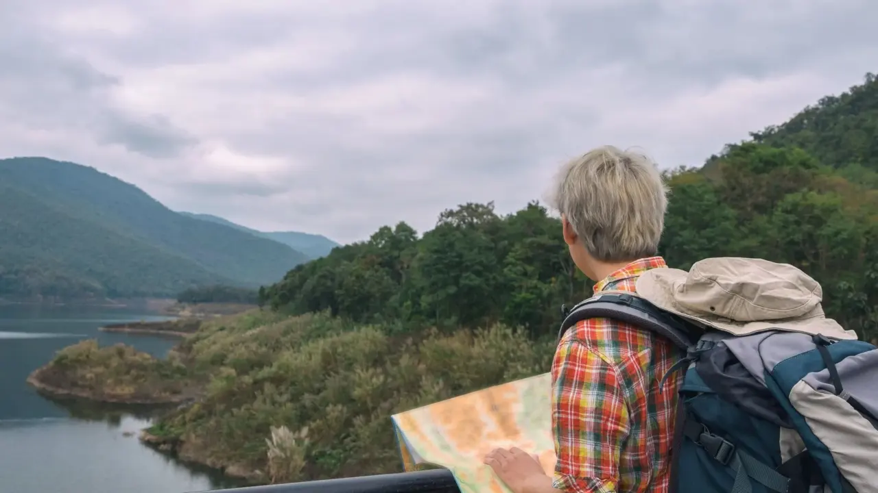 A traveller with a backpack looking at a map